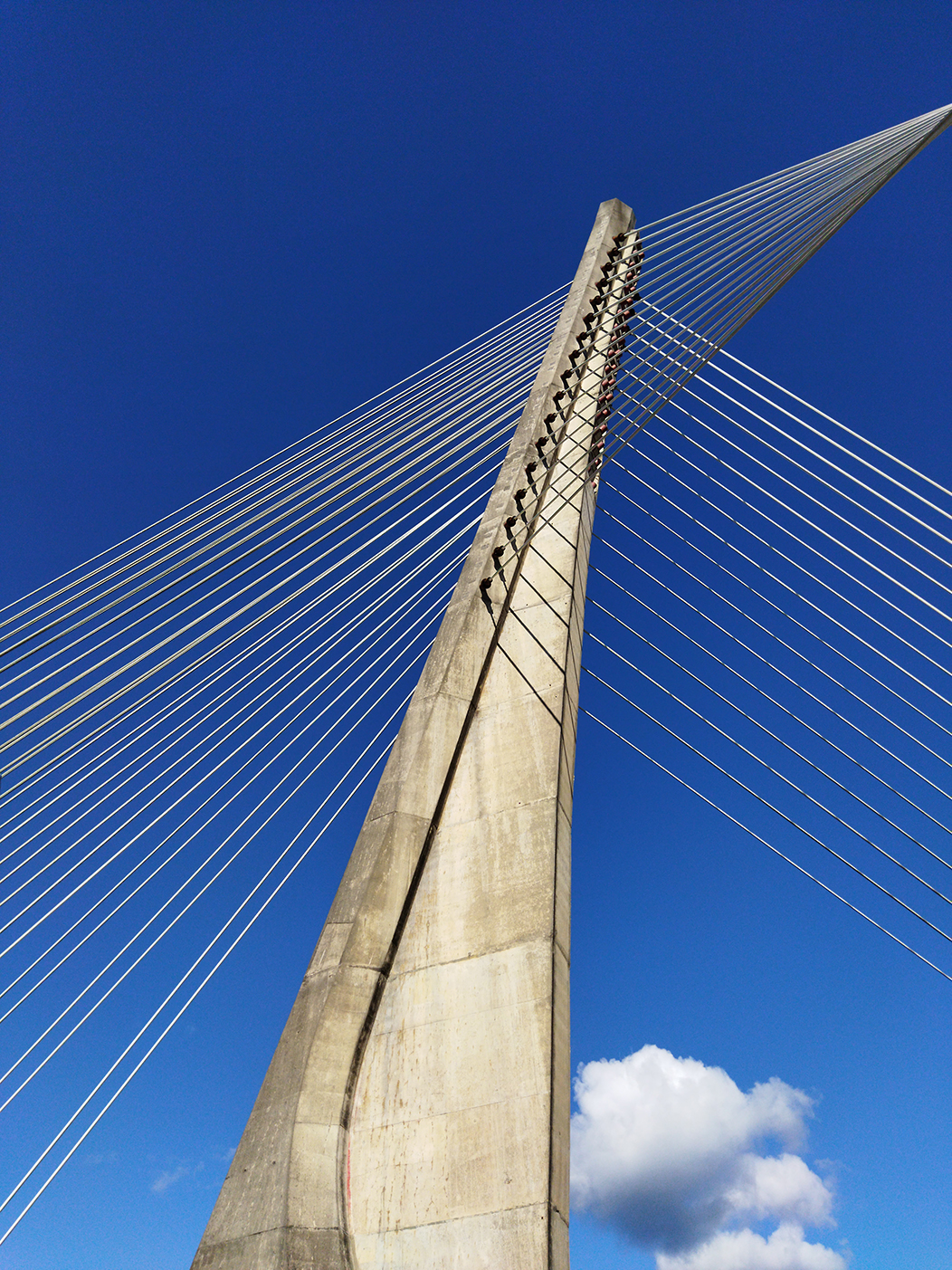 "Ponte", fotografía tomada en Pontevedra o 20-9-21. Mostra un dos piares da ponte colgante dos Tirantes, en Pontevedra, sobre un ceo azul intenso, cunha pequena nube.